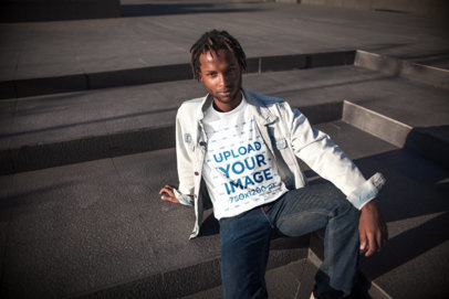 Mockup of a Man with Locs Wearing a Tee and Sitting on Steps