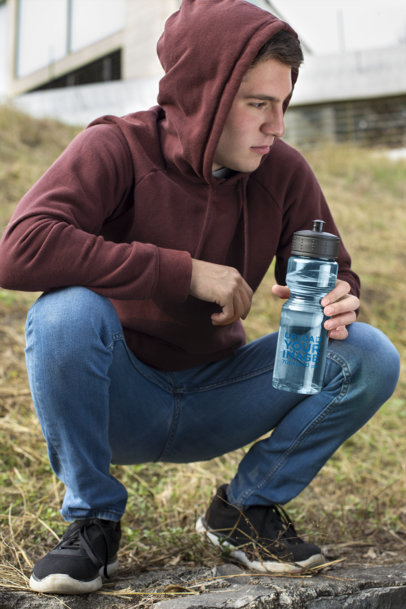 Water Bottle Mockup Featuring a Man Crouching in the Field 24440a