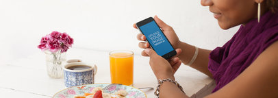 Mockup of a Woman at a Restaurant Using a Black iPhone 6