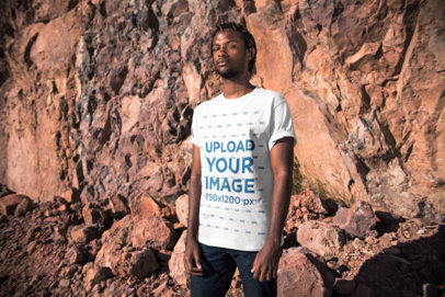 Mockup of a Serious Man Wearing a Tee Against Stones Outdoors