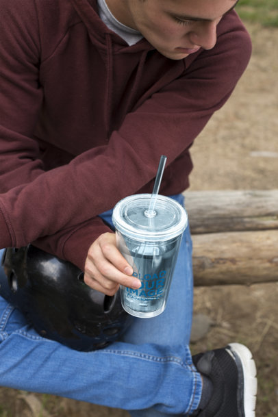 Tumbler Mockup Featuring a Serious Man Sitting with His Helmet 24436