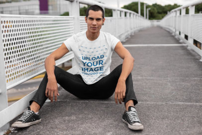 Round Neck Tee Mockup of a Smiling Man Sitting on a Bridge