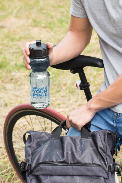 Mockup of a Water Bottle in the Hand of a Man Sitting on His Bike