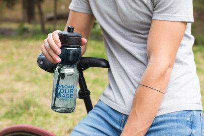 Mockup of a Transparent Sports Bottle Being Held by a Man