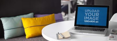 Laptop Mockup of a Macbook Sitting on Top of a Table Next to a Sofa