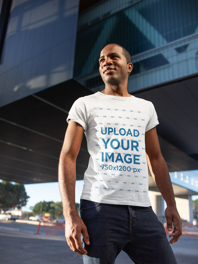 Tee Mockup of a Happy Man Standing Confidently in Front of a Building