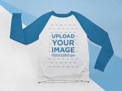 Mockup of a Raglan Crewneck Sweatshirt Laid Flat on a Tricolor Surface 24576
