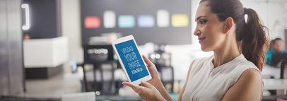 Tablet Mockup Featuring a Woman Using a White iPad at the Office 