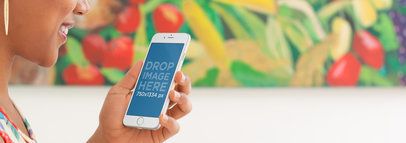 Mockup Template of a Woman Using an iPhone at a Colorful Restaurant