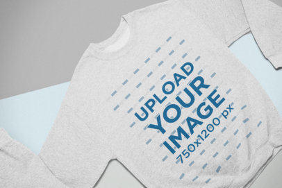 Mockup of a Heathered Crewneck Sweatshirt Lying on Colored Pasteboards
