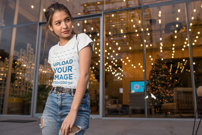 Mockup of a Woman Wearing a T-Shirt and Ripped Jeans in Front of an Office Lobby