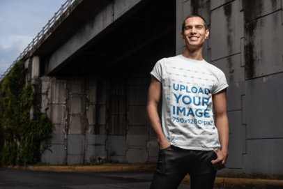 Mockup of a Smiling Man Wearing a Tee Under a Bridge