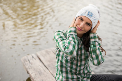 Mockup of a Woman Adjusting Her Beanie Sitting by a Lake  24628