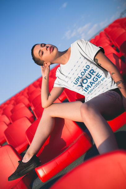 T-Shirt Mockup of an Alternative Woman With a Moon Tattoo Against Red Chairs