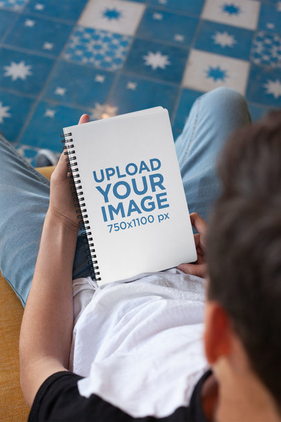 Mockup of a Notebook Held by a Brunette Boy