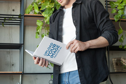 Notebook Mockup Featuring a Man with a Black Shirt