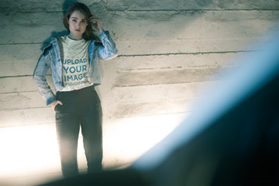 T-Shirt Mockup of a Woman Standing in Front of a Car's Headlights