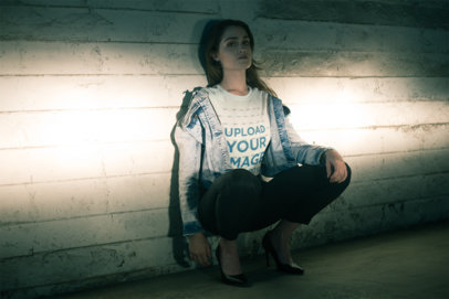 Tee Mockup of a Woman Crouching in Front of Car Headlights