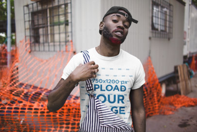 T-Shirt Mockup Featuring a Man with Overalls in a Urban Environment