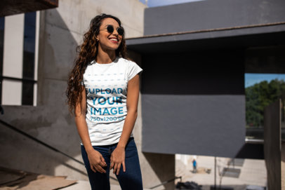 Urban Mockup of a Smiling Woman with Long Curly Hair Wearing a Tshirt
