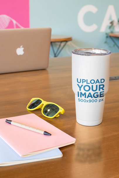 Mockup of a Tumbler Standing on a Wooden Desk
