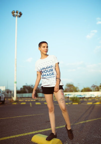 T-Shirt Mockup of a Smirking Woman Balancing on a Parking Stop 20188