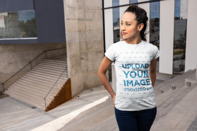 Mockup of a Woman Wearing a Tee in Front of a City Building