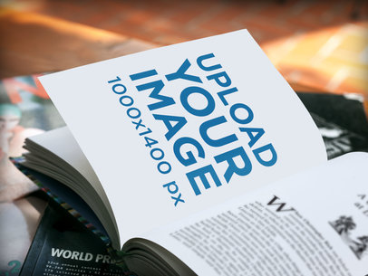 Mockup Featuring a Book Lying Open Over a Stack of Magazines a5909