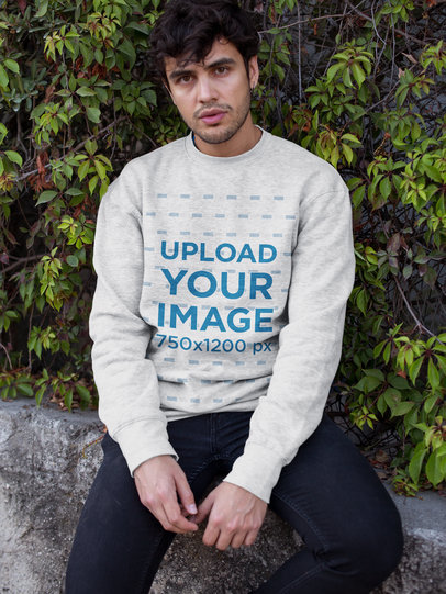 Crewneck Sweater Mockup Featuring a Man with Curly Hair Sitting Against Plants 18194