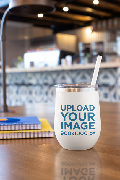 Mockup of a Tumbler with a Straw on a Wooden Surface