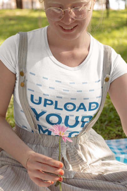 Mockup of a Smiling Woman Holding a Flower in a Park