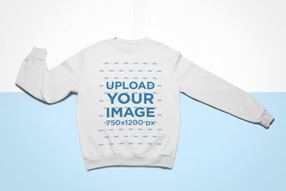 Mockup of a Crewneck Sweatshirt Lying Flat on a Colored Surface