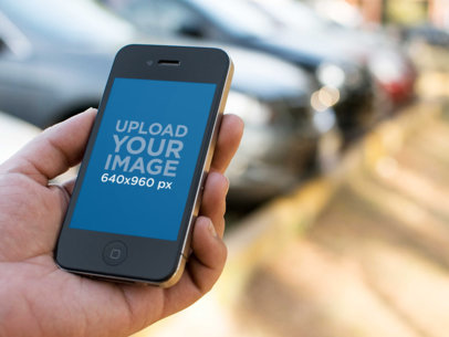 Woman Holding Black iPhone Between Cars