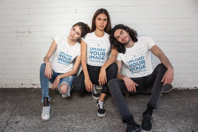 Mockup of Three Friends Wearing T-Shirts Crouching Against a Wall