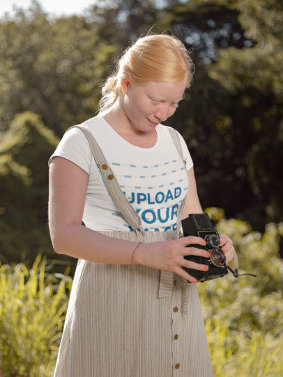 T-Shirt Mockup of a Woman Taking a  Picture with Her Vintage Camera