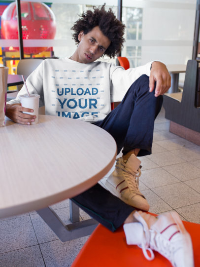 Mockup of a Man with an Afro Wearing a Sweatshirt in a Fast Food Restaurant 18339