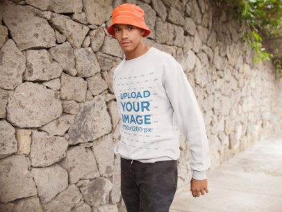 Crewneck Sweatshirt Mockup of a Man Walking by a Stone Wall