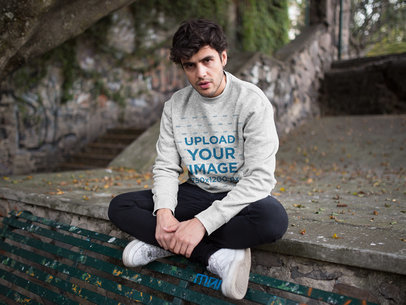 Mockup of a Serious Man Wearing a Heathered Sweater at a Park