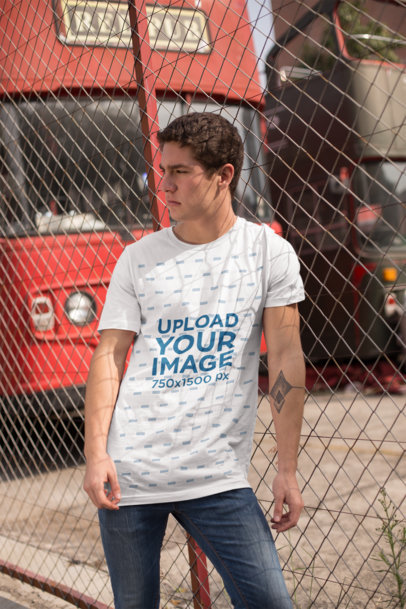 Mockup of a Man Wearing a Tee in Front of an English Style Bus 25297