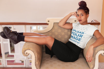 T-Shirt Mockup of a Woman with Braids Sitting on an Armchair