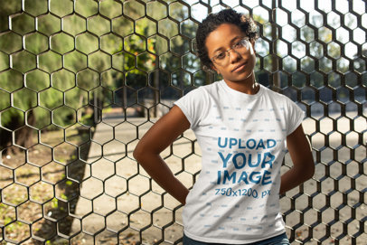 T-Shirt Mockup of a Curly Haired Woman Leaning on a Fence