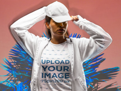 Mockup of a Woman Wearing a Tee and a Hat in a Studio