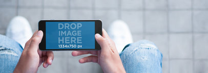 iPhone Mockup Featuring a Guy on the Street Using a Black iPhone 6