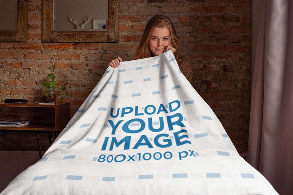 Throw Blanket Mockup Featuring a Woman Sitting on a Bed