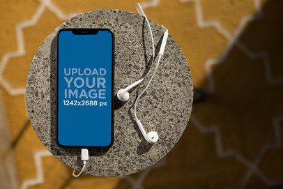 Mockup of an iPhone XS Max over a Stone Pillar 24789