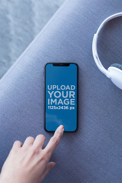 Mockup of an iPhone X Resting on a Couch Playing a Podcast 24793