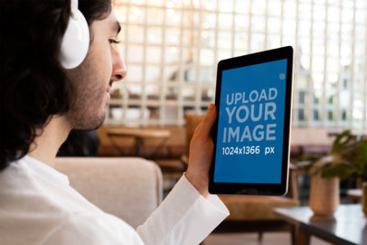 iPad Mockup of a Man Listening to a Podcast with Headphones