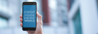 iPhone Mockup Featuring a Guy on the Street Holding a Black iPhone 7