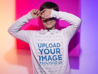 Sweatshirt Mockup Featuring a Woman Covering Her Face Playfully