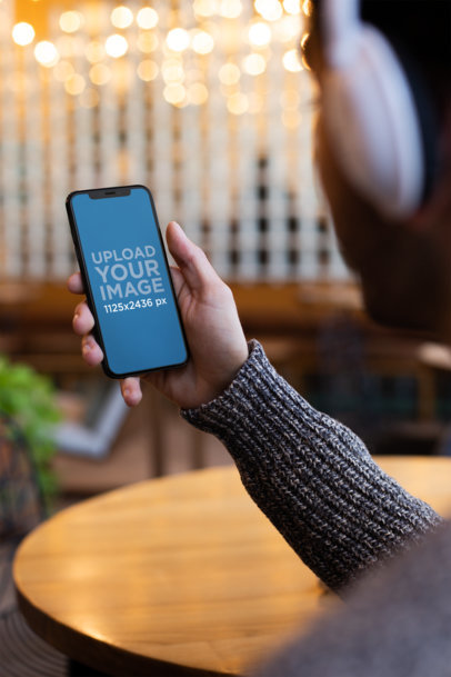 Mockup of an iPhone 11 Pro Held by a Man Listening to a Podcast